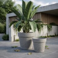 Jumbo and Super Jumbo light gray stone textured round planters outside a modern residence