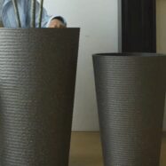 Detailed view of a black stone textured tall round planter